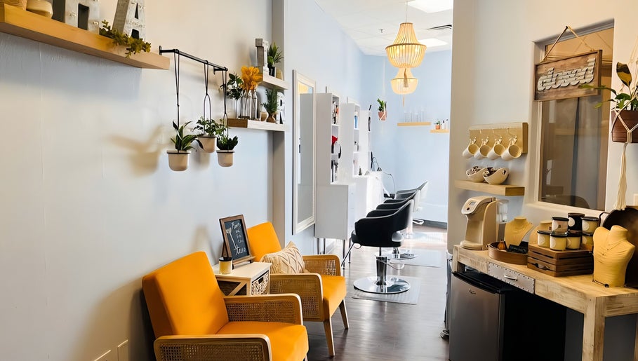 Bright, modern salon entrance at Curl & Color Studio, Las Vegas, Nevada, US with stylish chairs and hanging plants.