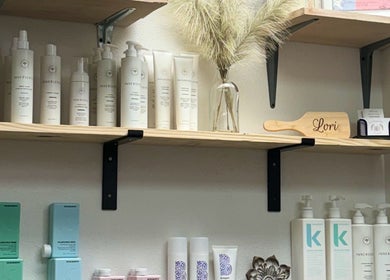 Product shelves at Uninhibited Curls by Lori Peppin Hair, showcasing haircare items in Lubbock, Texas, US.