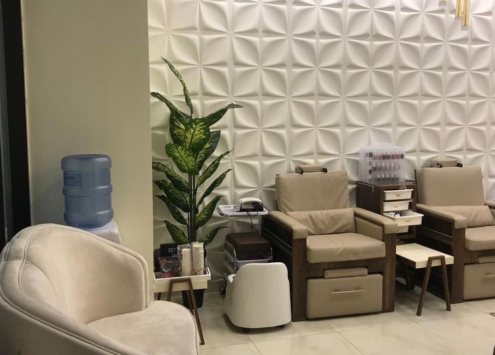 Pedicure lounge area at New Tec Saloon, Dubai, Dubai, AE with cozy chairs and modern decor.