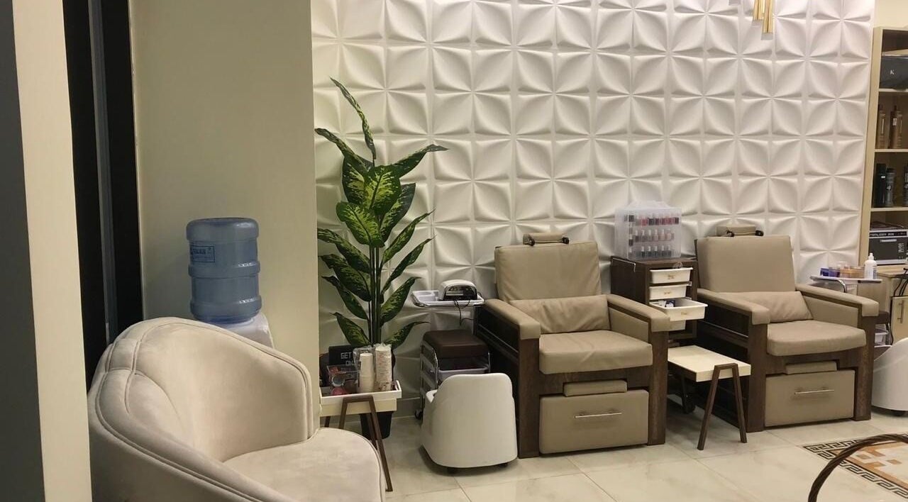 Pedicure lounge area at New Tec Saloon, Dubai, Dubai, AE with cozy chairs and modern decor.