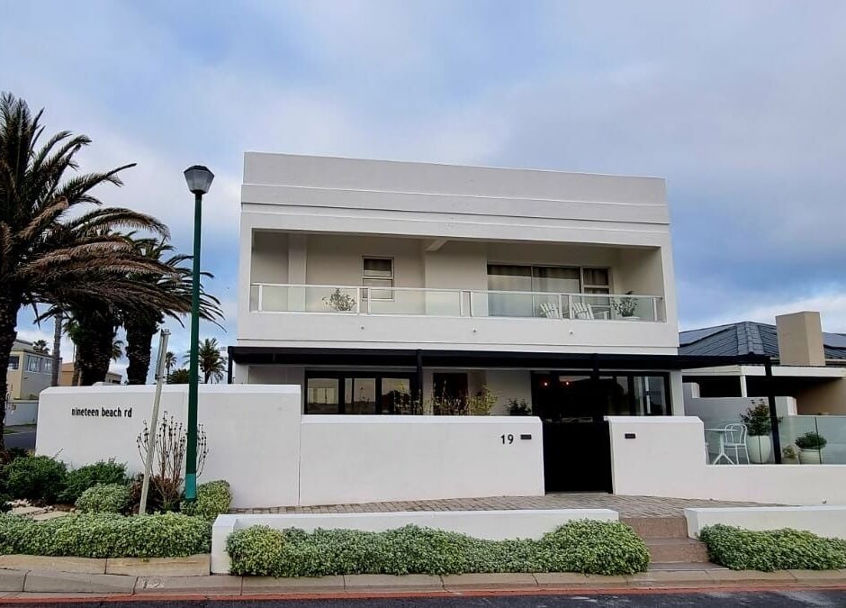 Satori Wellness @ NORTH STAR RETREAT in Melkbosstrand, Western Cape, ZA: modern facade with palm trees.