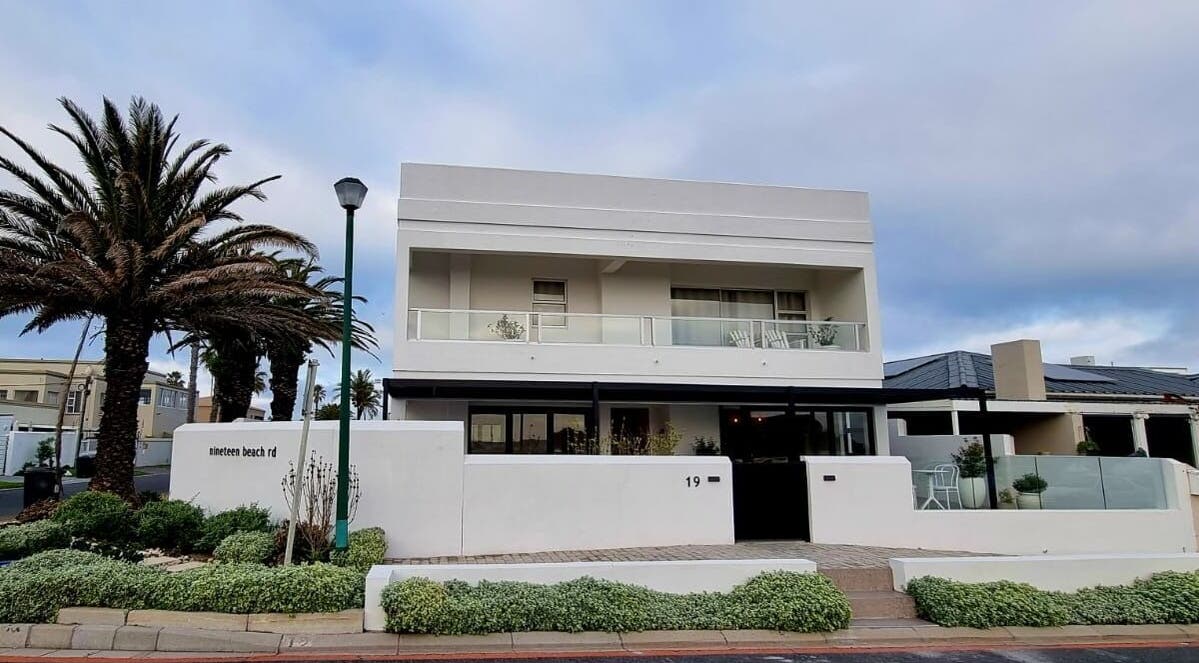 Satori Wellness @ NORTH STAR RETREAT in Melkbosstrand, Western Cape, ZA: modern facade with palm trees.