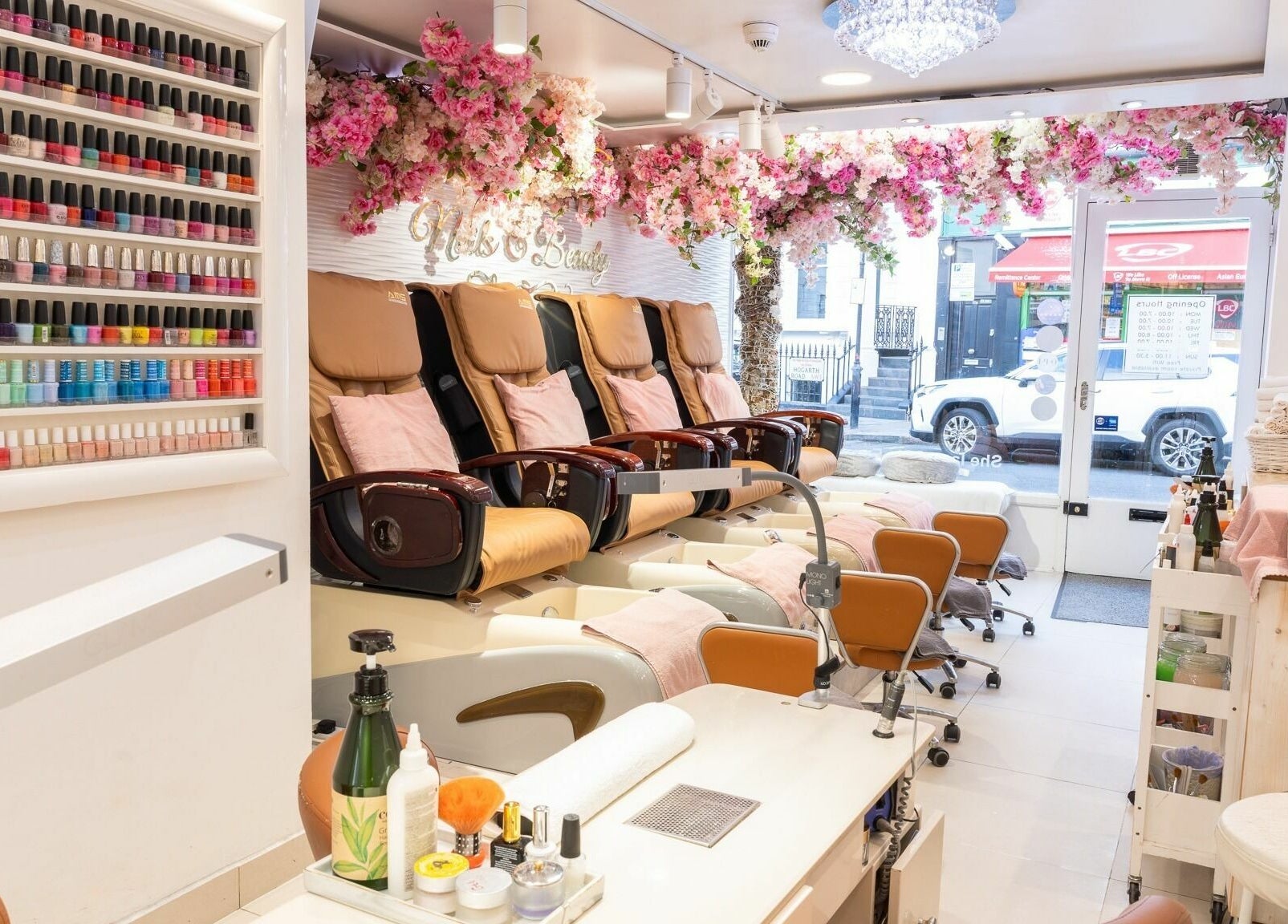 Luxurious nail salon at Serenity Earl's Court, London, England, GB, featuring floral decor and vibrant polish selection.