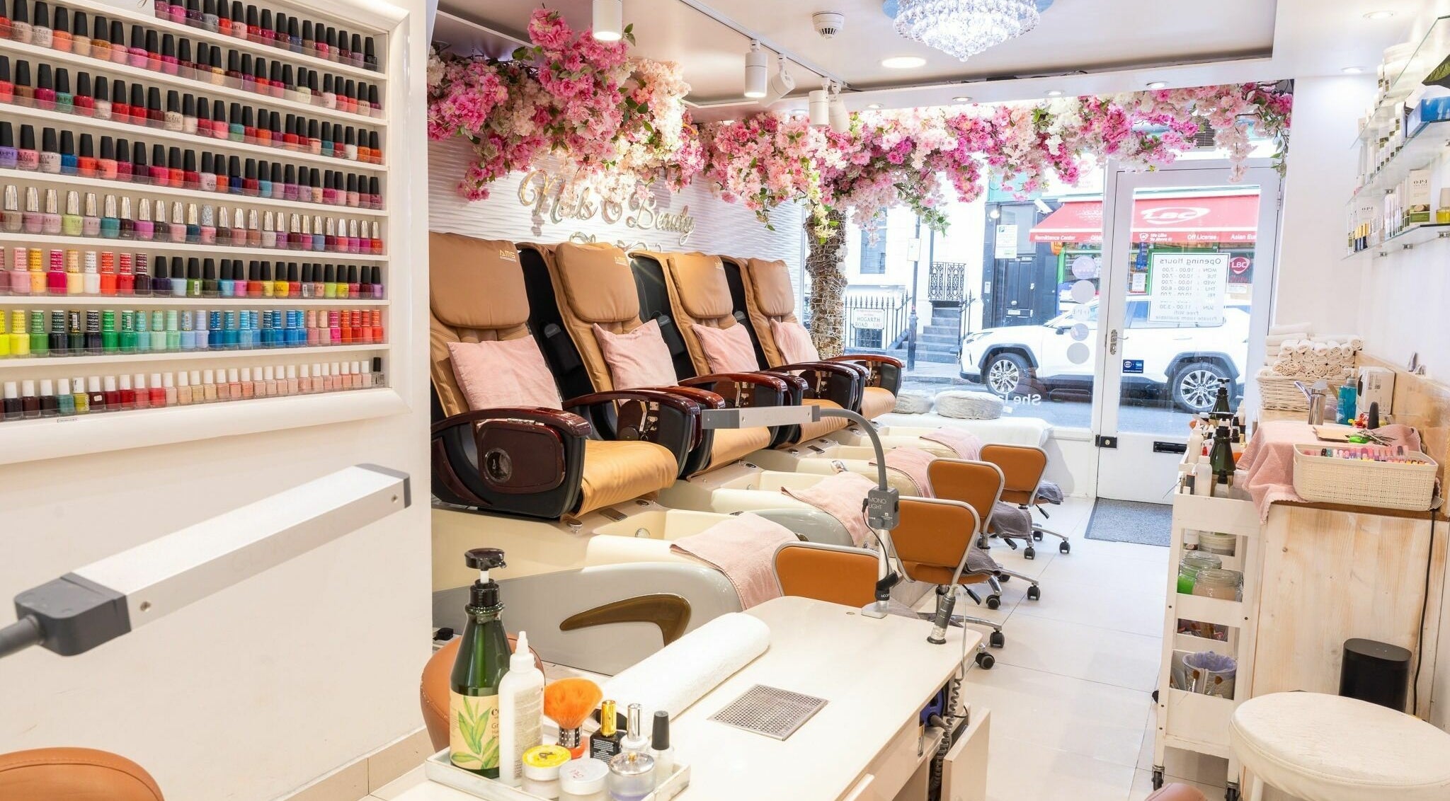 Luxurious nail salon at Serenity Earl's Court, London, England, GB, featuring floral decor and vibrant polish selection.