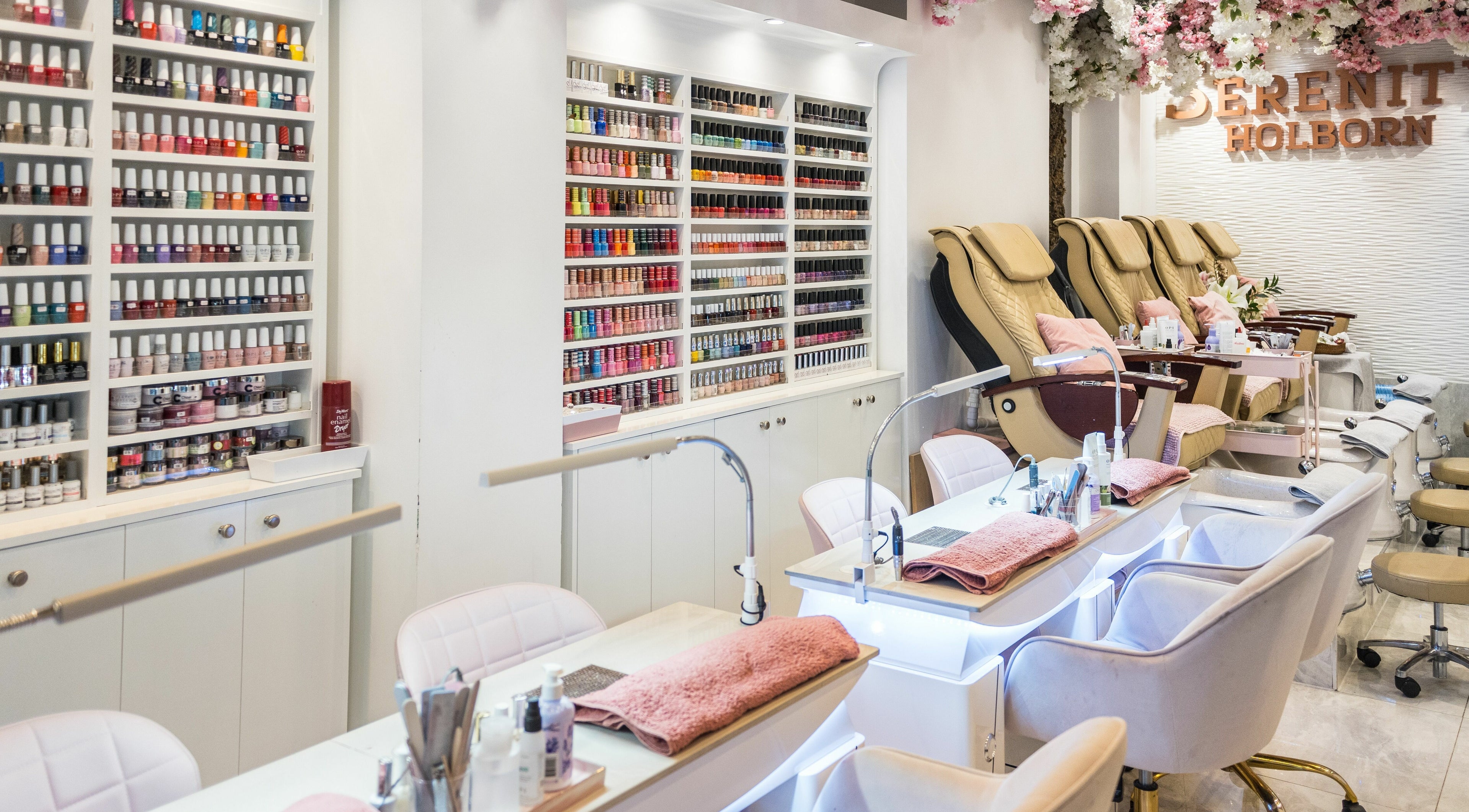 Nail salon interior at Serenity Holborn, London, England, GB, showcasing manicure stations and polishes.