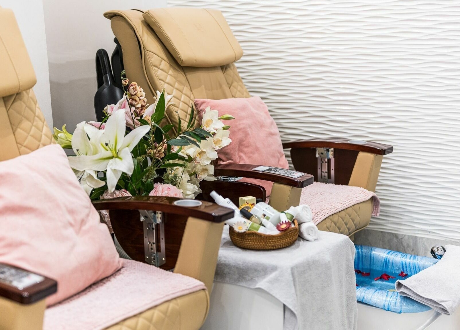 Luxury pedicure chairs at Serenity Holborn, London, England, GB, featuring plush cushions and floral decor.