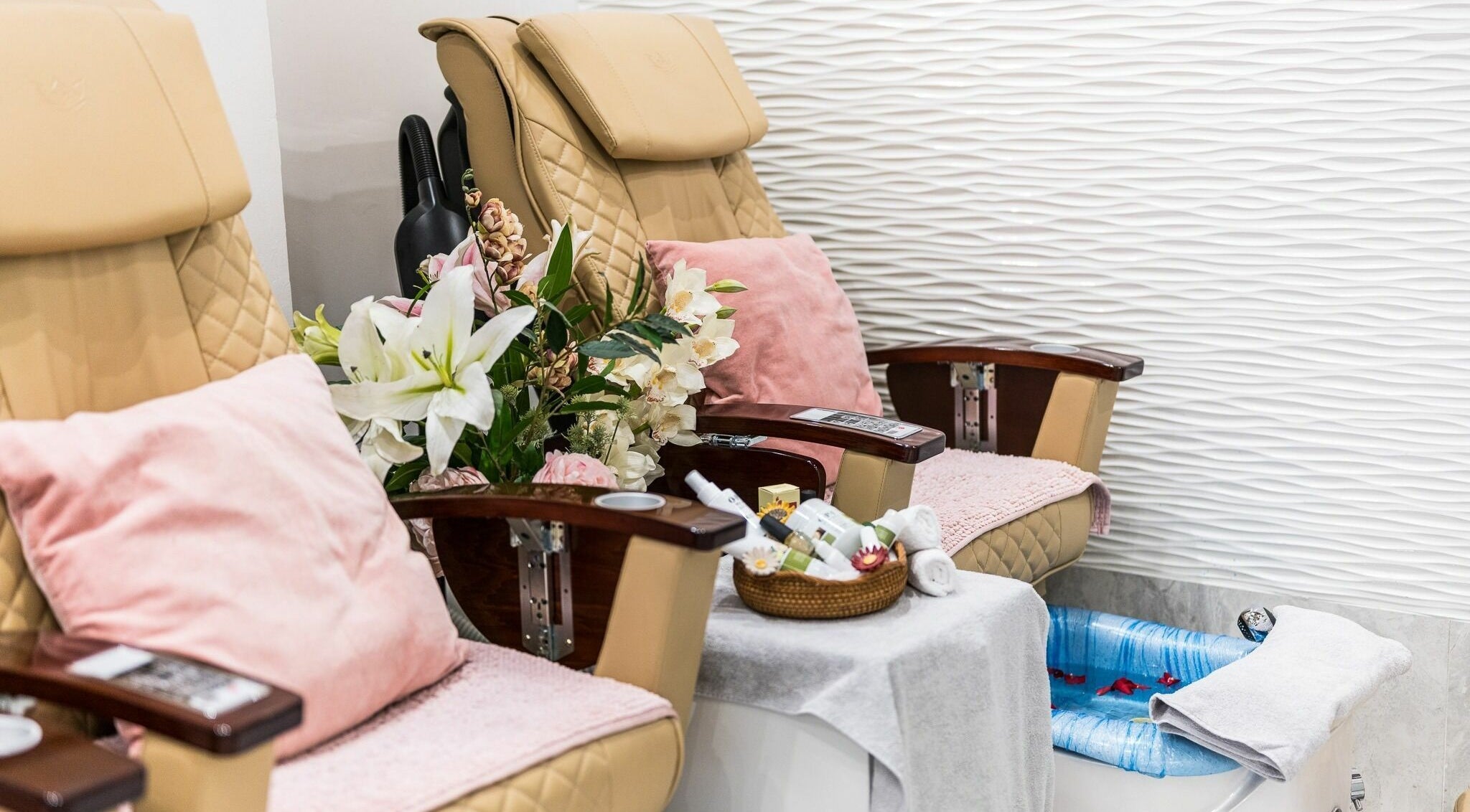 Luxury pedicure chairs at Serenity Holborn, London, England, GB, featuring plush cushions and floral decor.