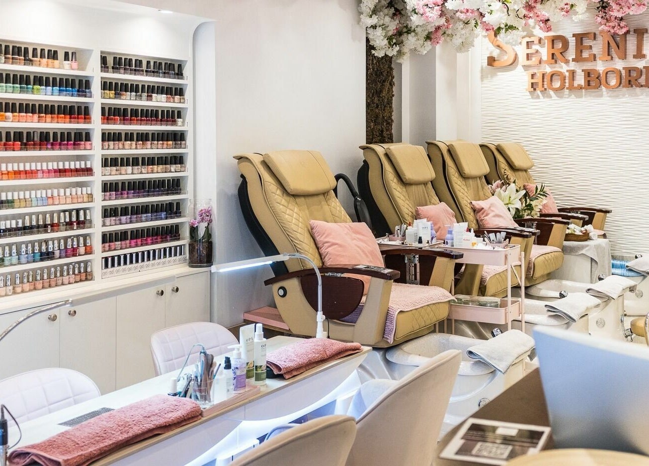Luxurious nail salon at Serenity Holborn, London, England, GB with plush chairs and colorful polish display.