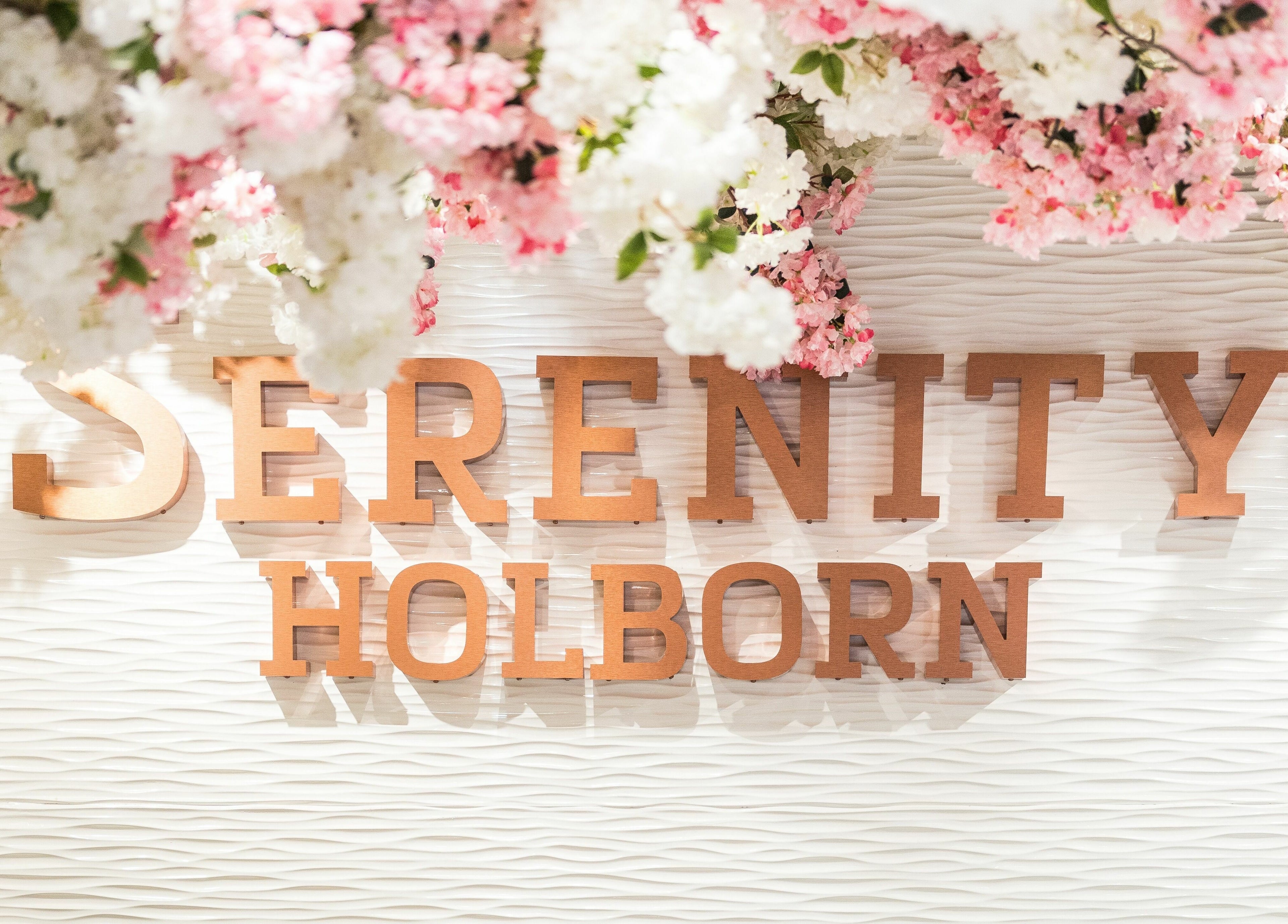 Serenity Holborn signage adorned with pink blossoms in London, England, GB.