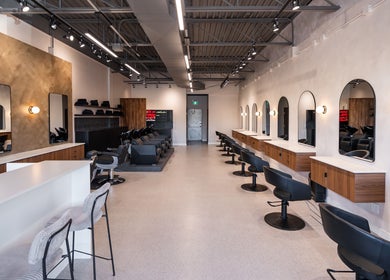 Modern styling area at In The Cut Salon in Montréal, Québec, CA with sleek chairs and mirrors.