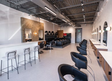 Modern interior of In The Cut Salon, Montréal, Québec, CA, featuring sleek styling stations and seating.