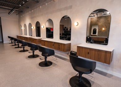 Modern interior of In The Cut Salon, Montréal, Québec, CA, featuring sleek styling stations and mirrors.