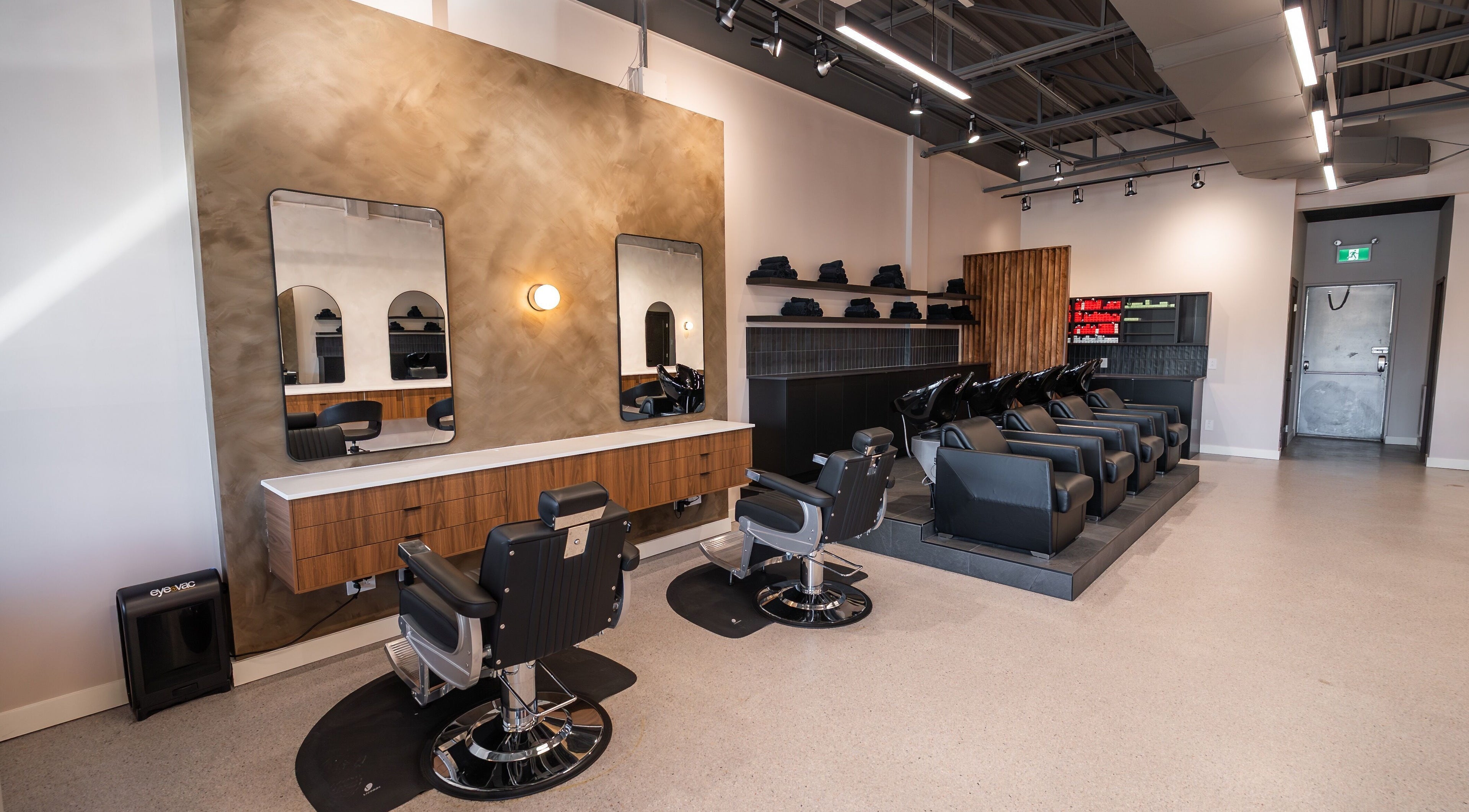 Chic interior of In The Cut Salon, Montréal, Québec, CA. Features sleek styling stations and wash basins.