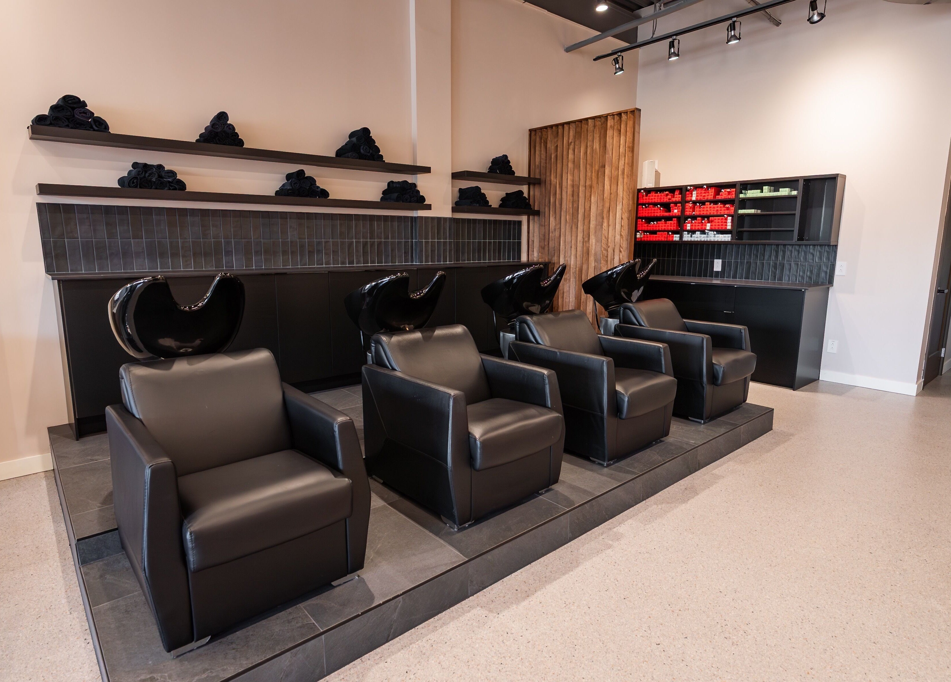 Luxurious wash stations at In The Cut Salon, Montréal, Québec, CA, showcasing modern black chairs.