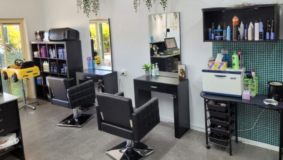 Modern interior of Bring It On Hair salon in Bellmere, Queensland, AU, featuring sleek styling stations and products.