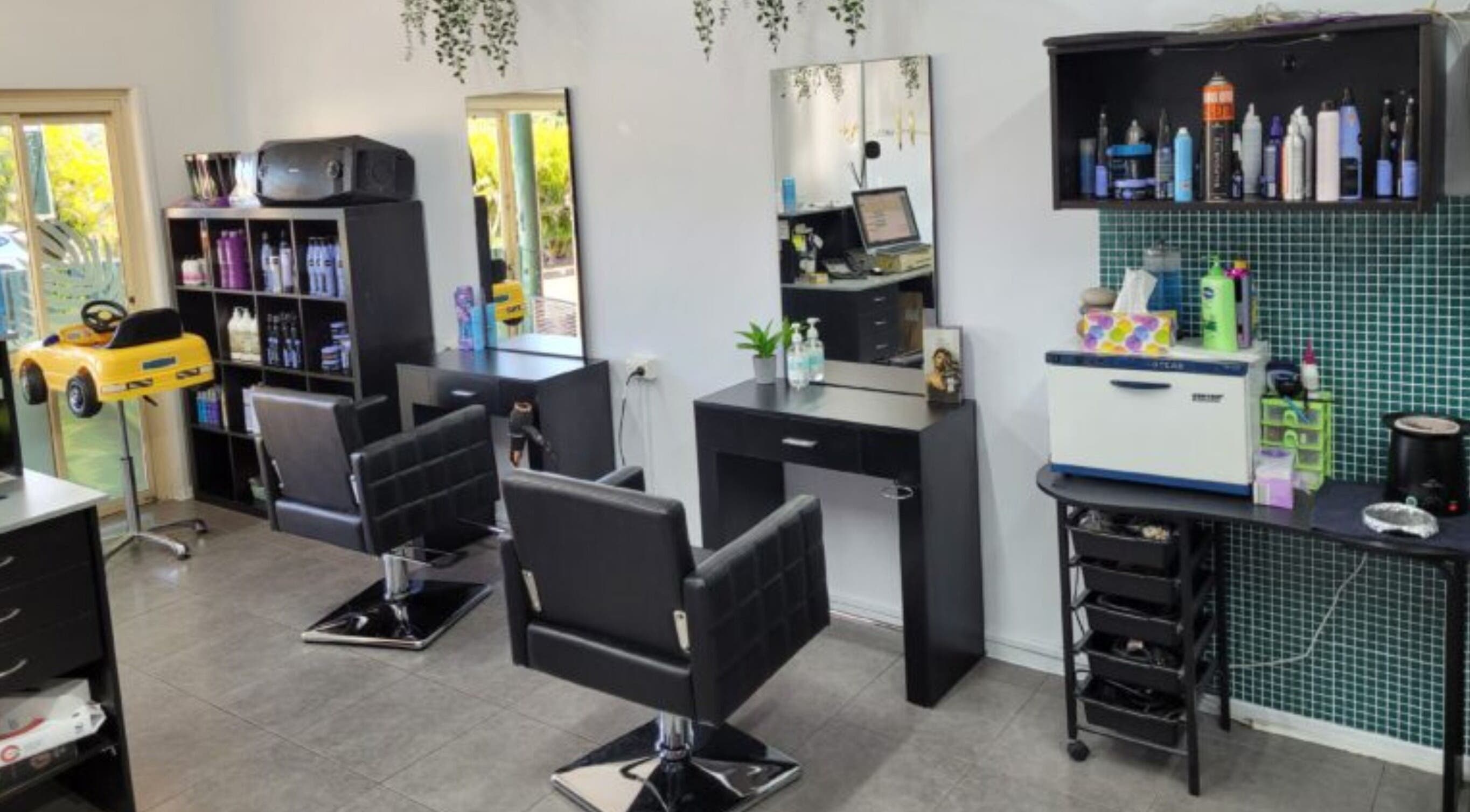 Modern interior of Bring It On Hair salon in Bellmere, Queensland, AU, featuring sleek styling stations and products.