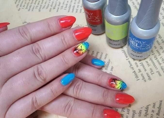 Bright nail art at Lucie's Nails and Beauty in Tas-Sliema, MT featuring colorful designs and polish bottles.