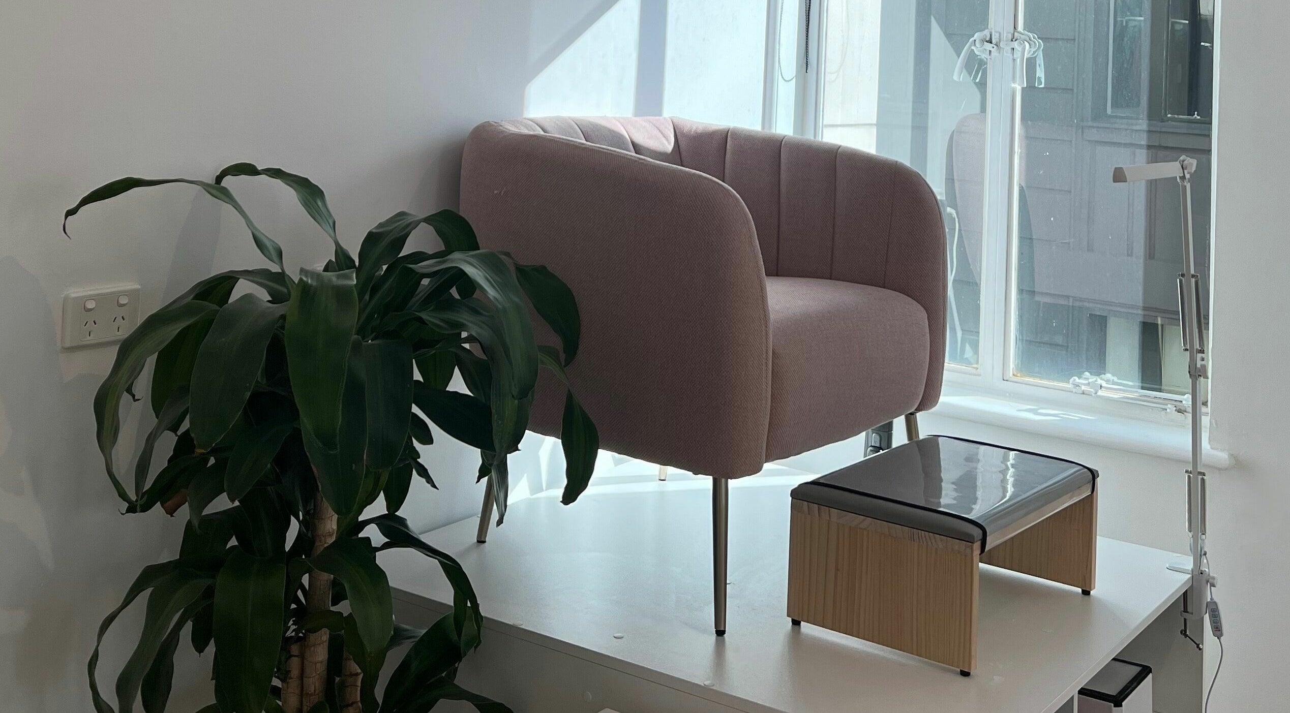Elegant pink chair beside a lush plant at Beauty Moah, Melbourne, Victoria, AU.