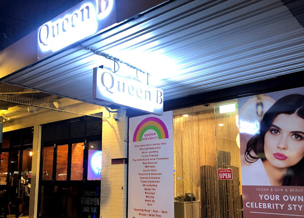 Queen B Skin and Beauty entrance in Melbourne, Victoria, AU, illuminated with bright signage and a stylist poster.