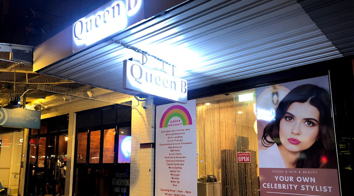 Queen B Skin and Beauty entrance in Melbourne, Victoria, AU, illuminated with bright signage and a stylist poster.