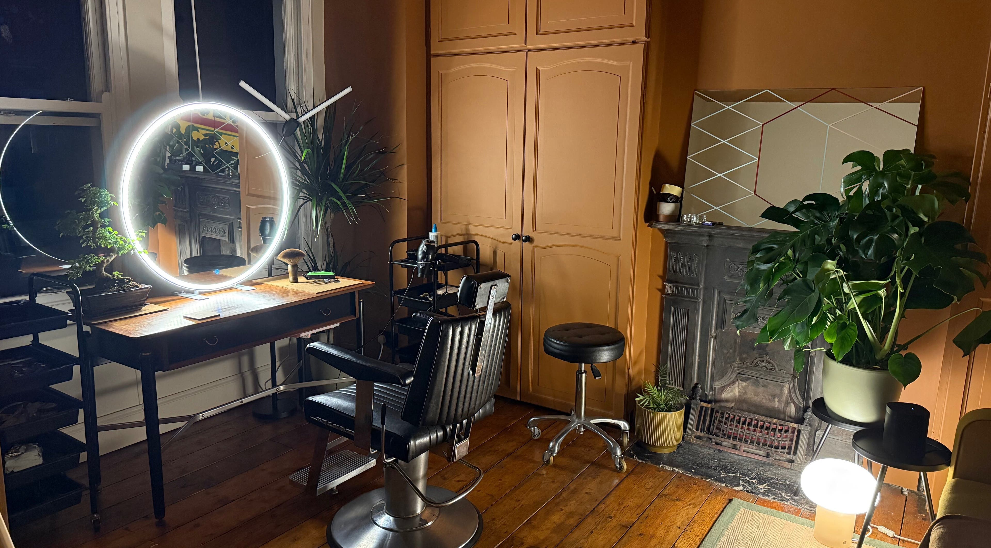 Chic interior of Stuart Weller Hair in Brighton, England, GB with stylish mirrors and lush plants.