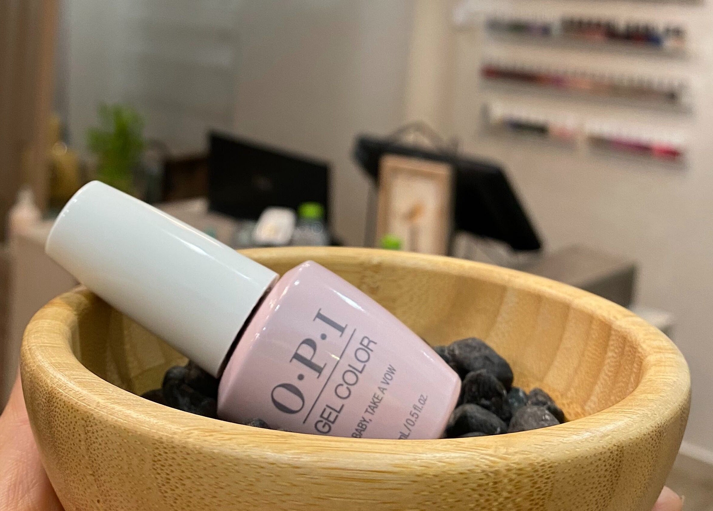 OPI gel polish in a wooden bowl at Dopamine Spa, Ras al Khaimah, AE. Enhance your nail beauty.