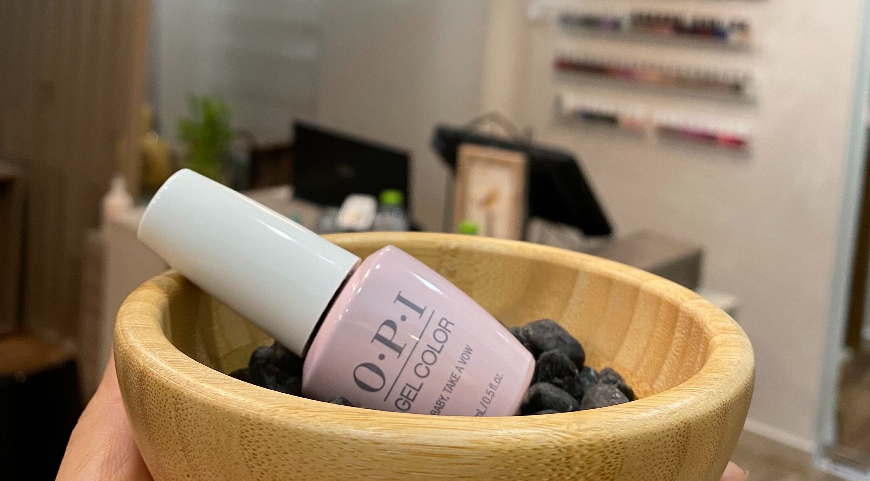 OPI gel polish in a wooden bowl at Dopamine Spa, Ras al Khaimah, AE. Enhance your nail beauty.