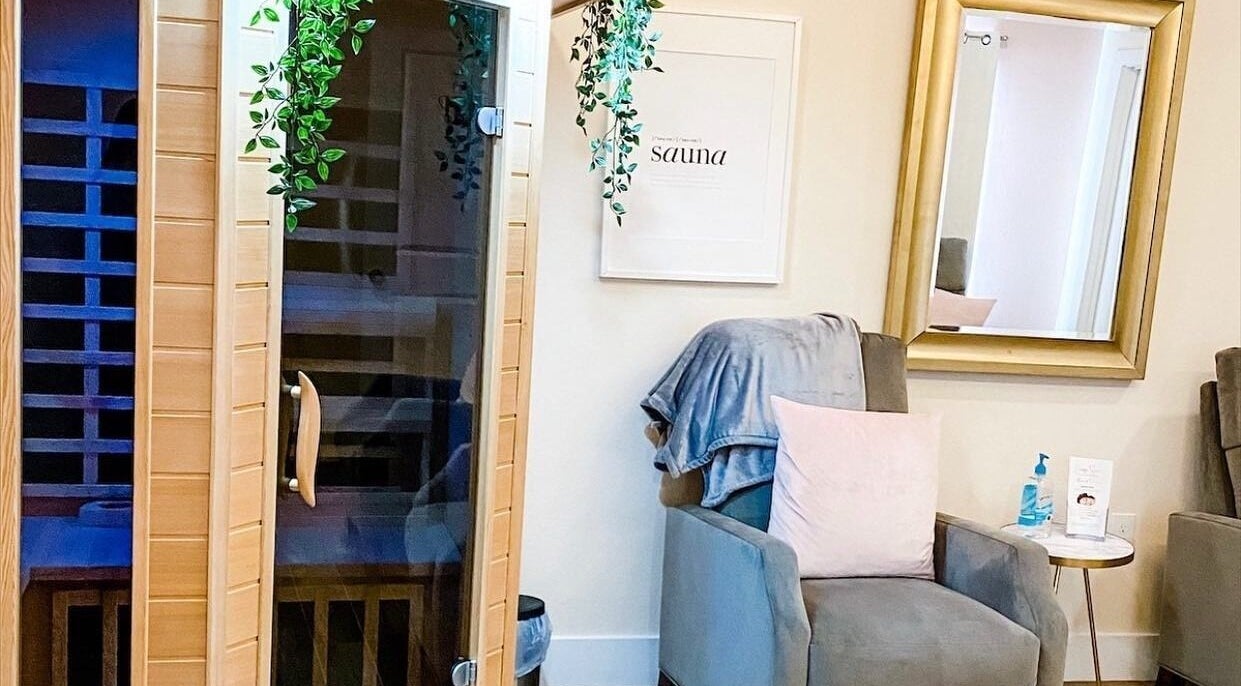 Relaxing sauna room at Energe Spa, Cypress, Texas, US, featuring a cozy chair and lush greenery.