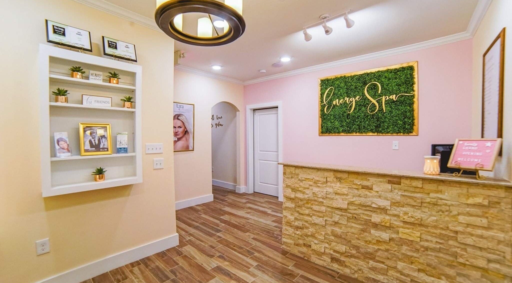 Energe Spa reception area with elegant decor in Cypress, Texas, US, featuring a green wall and cozy ambiance.