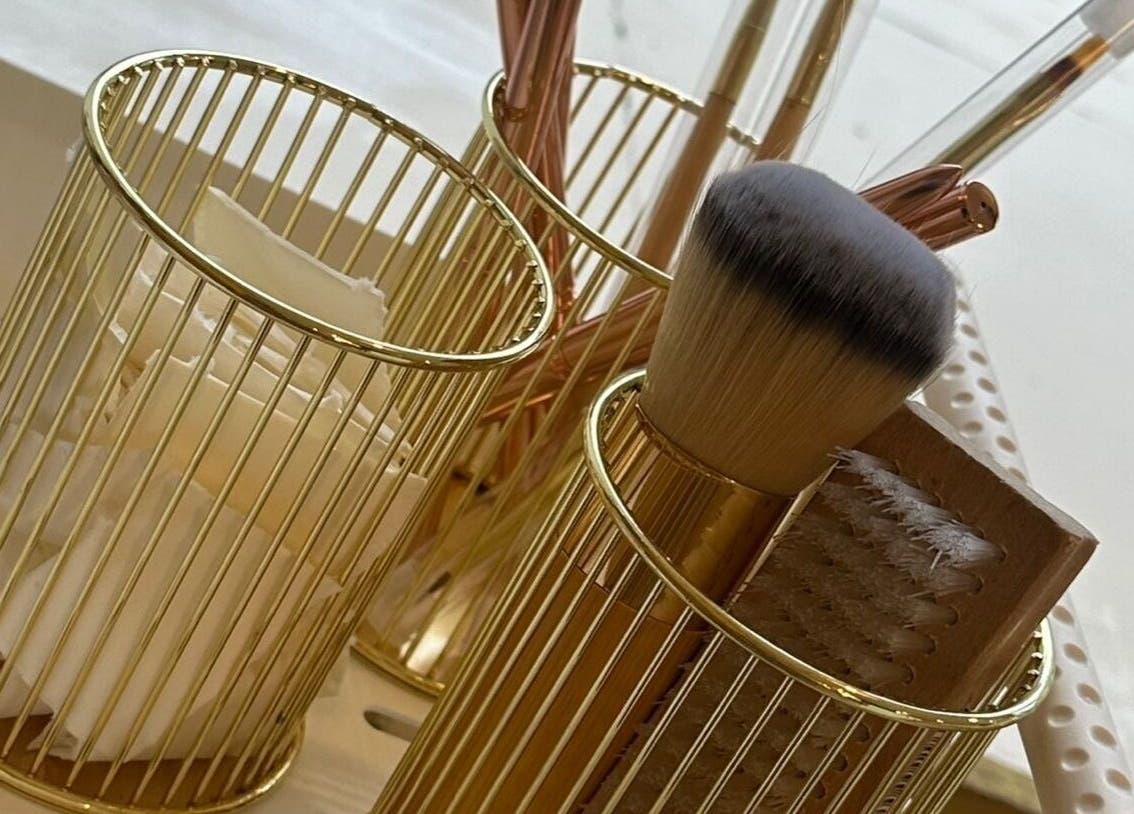 Elegant makeup brushes in gold holders at Rachael Louise & Co, Glasgow, Scotland, GB.