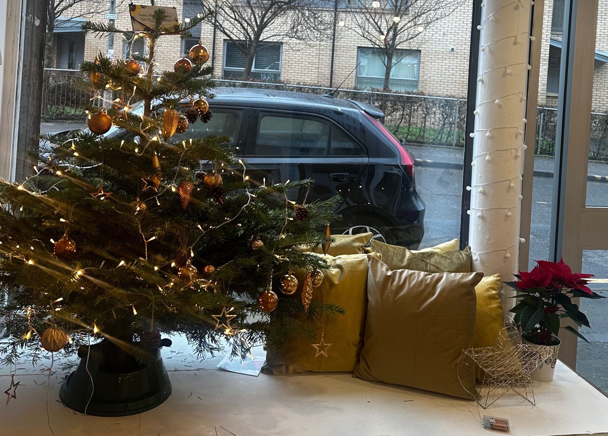 Festive Christmas setup at Rachael Louise & Co in Glasgow, Scotland, GB, showcasing a decorated tree and pillows.