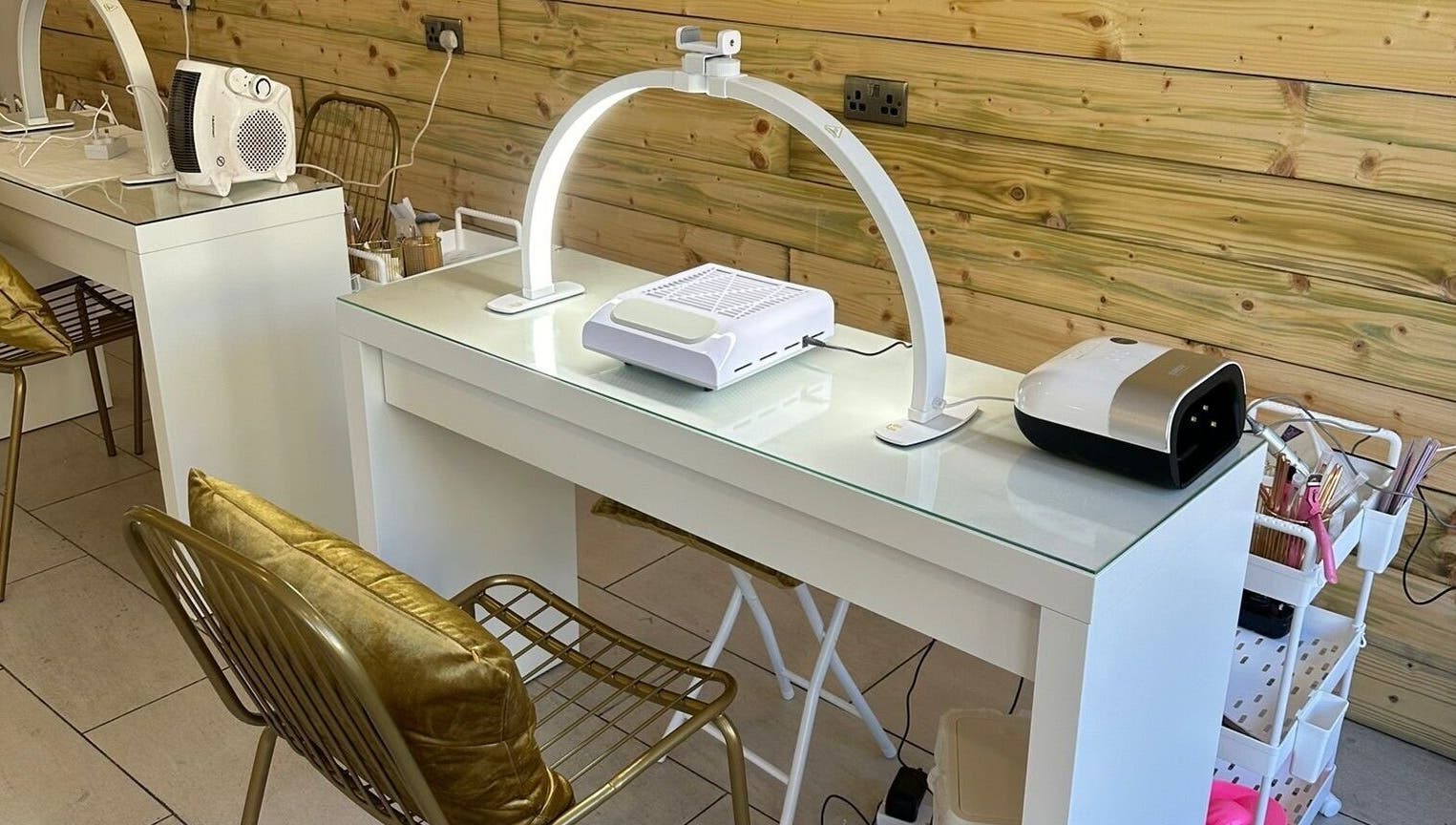 Stylish nail station at Rachael Louise & Co, Glasgow, Scotland, GB, featuring chic gold chairs and modern equipment.