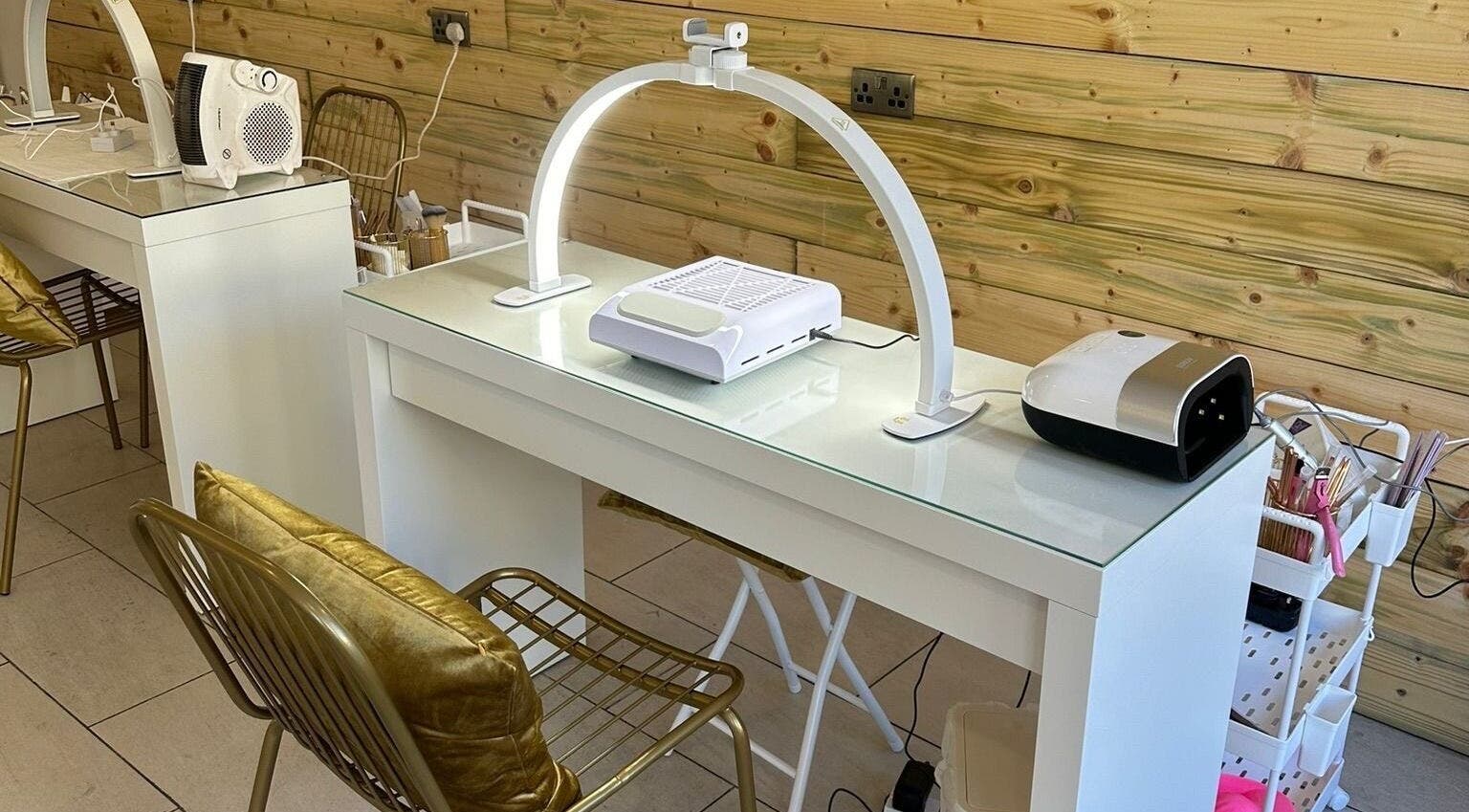 Stylish nail station at Rachael Louise & Co, Glasgow, Scotland, GB, featuring chic gold chairs and modern equipment.