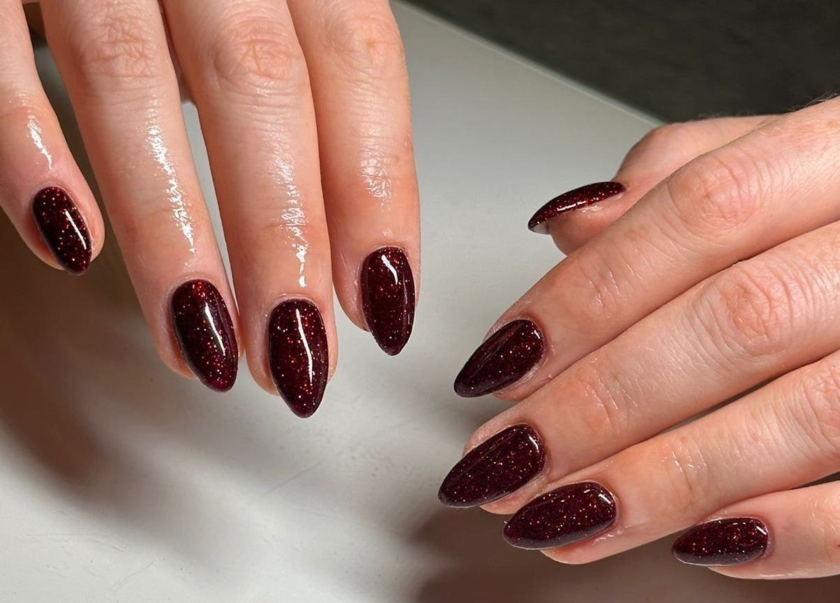 Sparkling crimson nails at Rachael Louise & Co in Glasgow, Scotland, GB, showcasing expert manicure artistry.