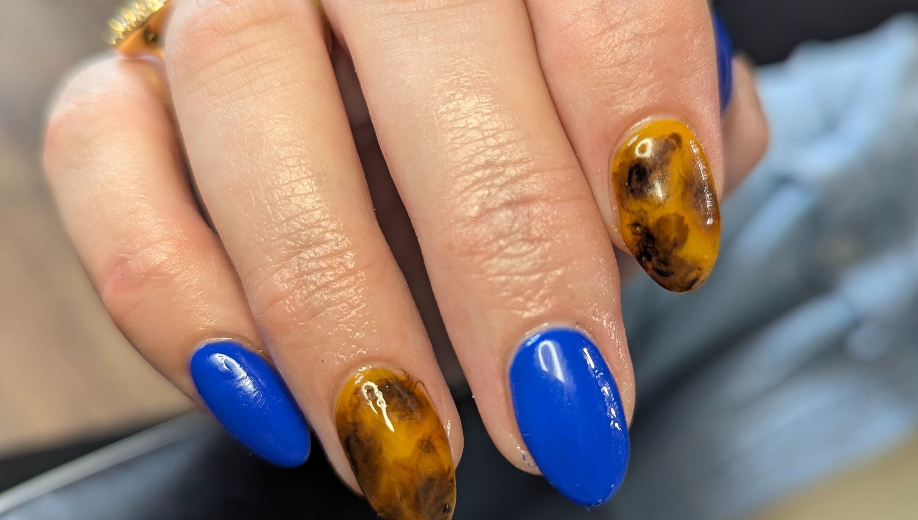 Bold nail art with vibrant blue and marble designs at Kathsklaws, Wolverhampton, England, GB.