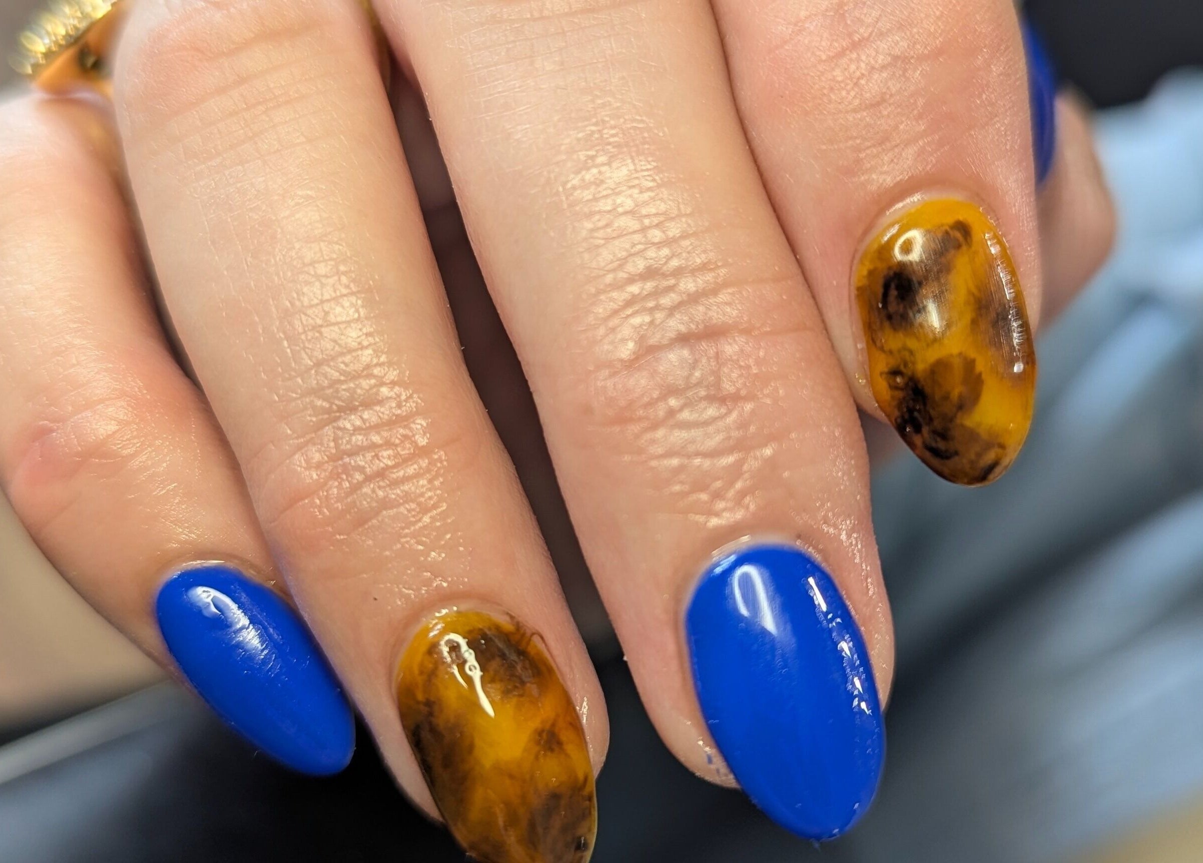 Bold nail art with vibrant blue and marble designs at Kathsklaws, Wolverhampton, England, GB.