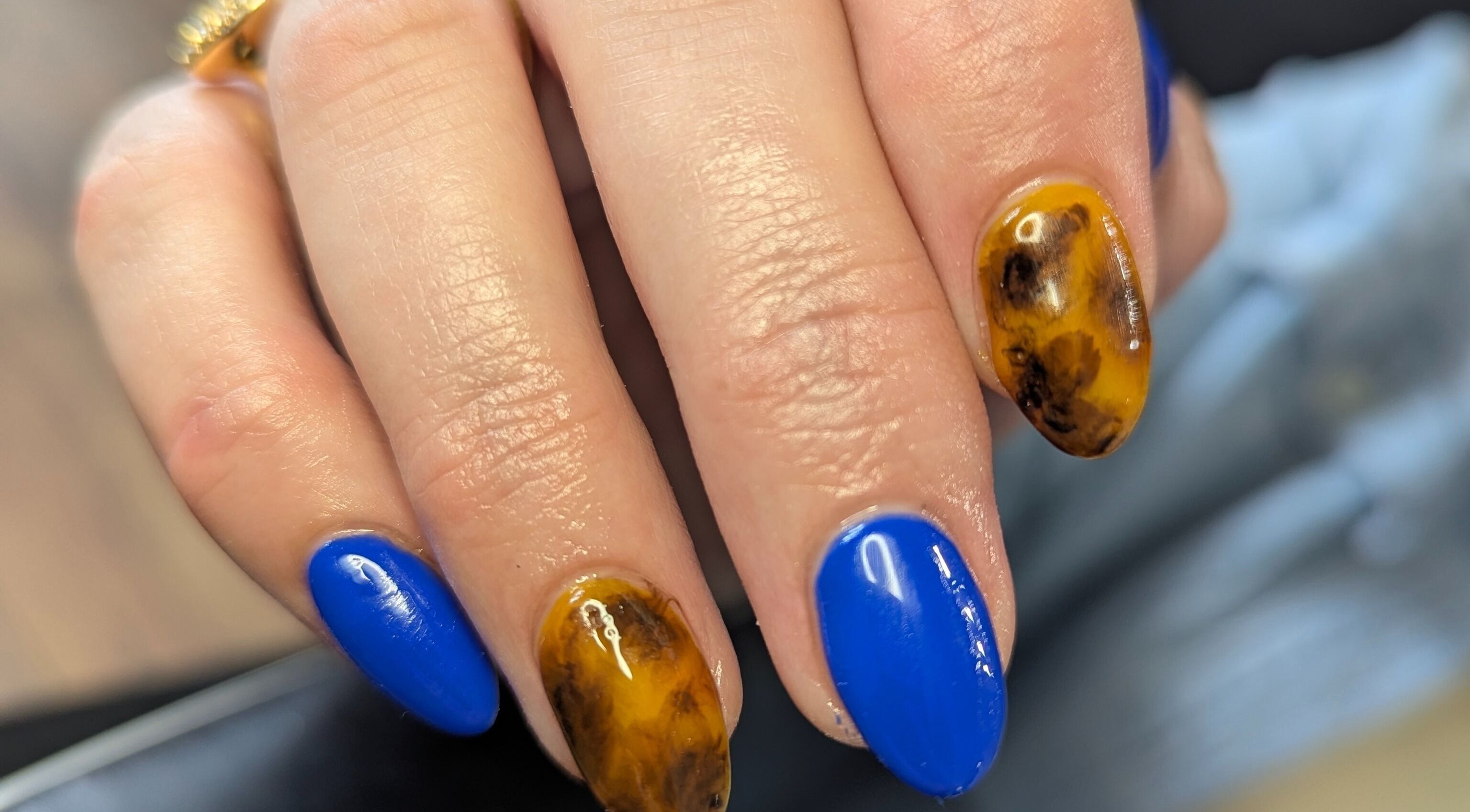 Bold nail art with vibrant blue and marble designs at Kathsklaws, Wolverhampton, England, GB.
