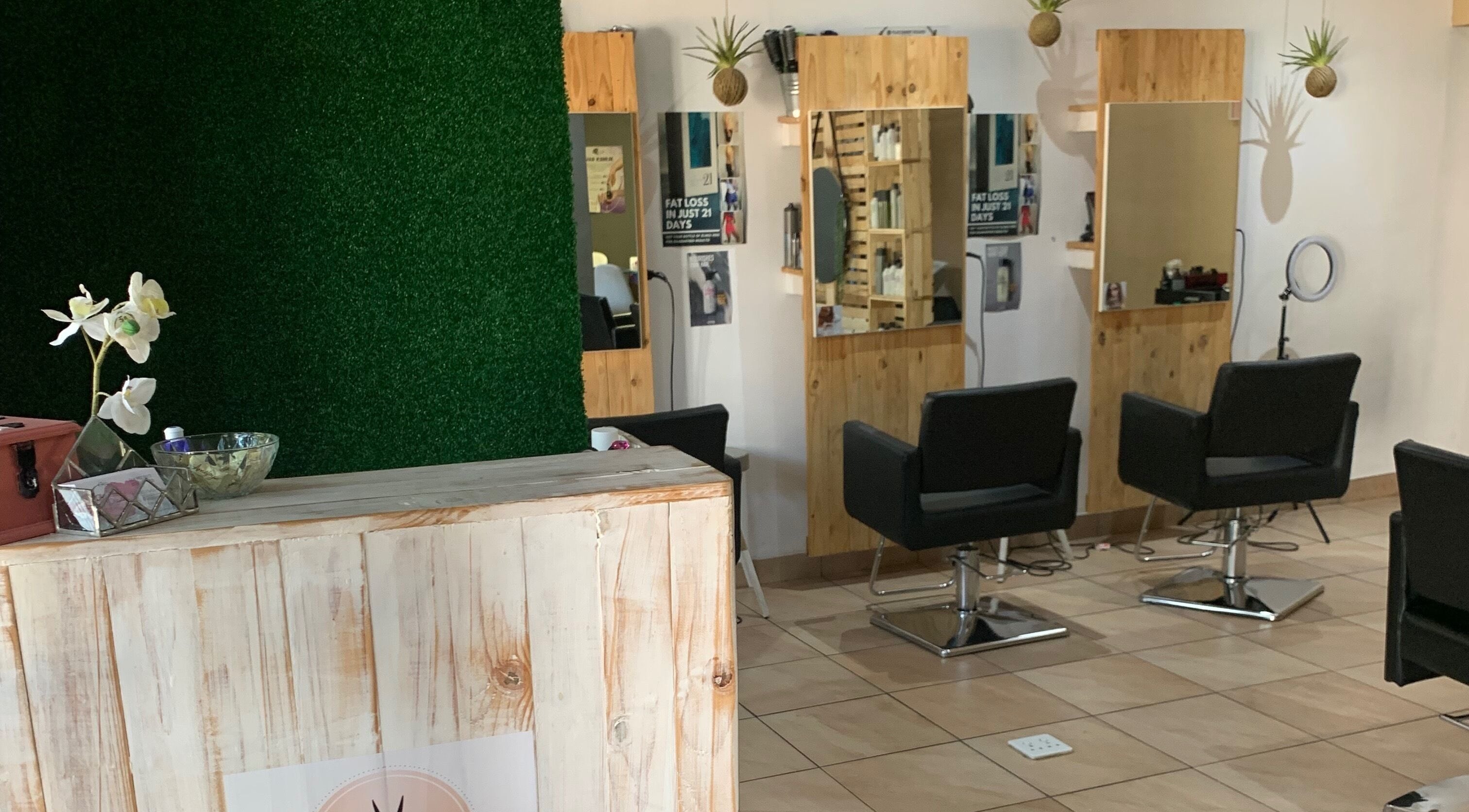 Chic salon interior of Polished Pixie Hair Design, Benoni, Gauteng, ZA with stylish chairs and wooden accents.