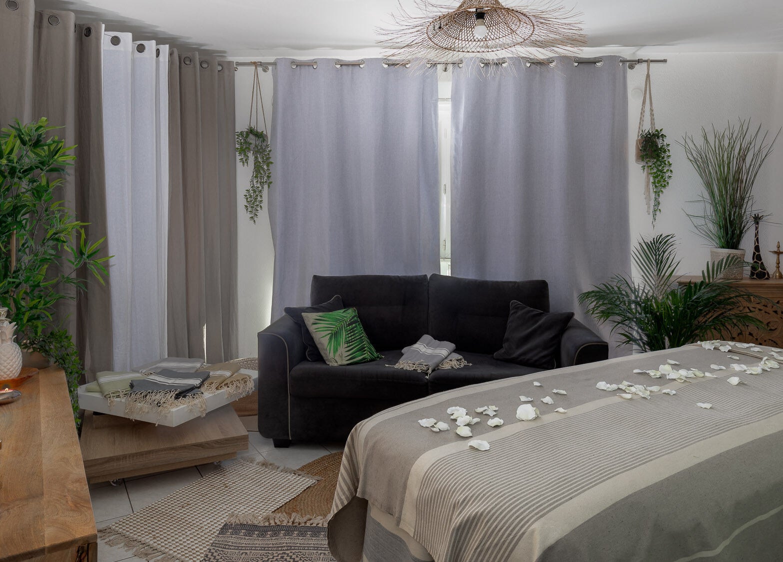 Salle de bien-être sereine à Pranaveda, Lyon, Auvergne-Rhône-Alpes, FR avec un canapé et des pétales blancs.