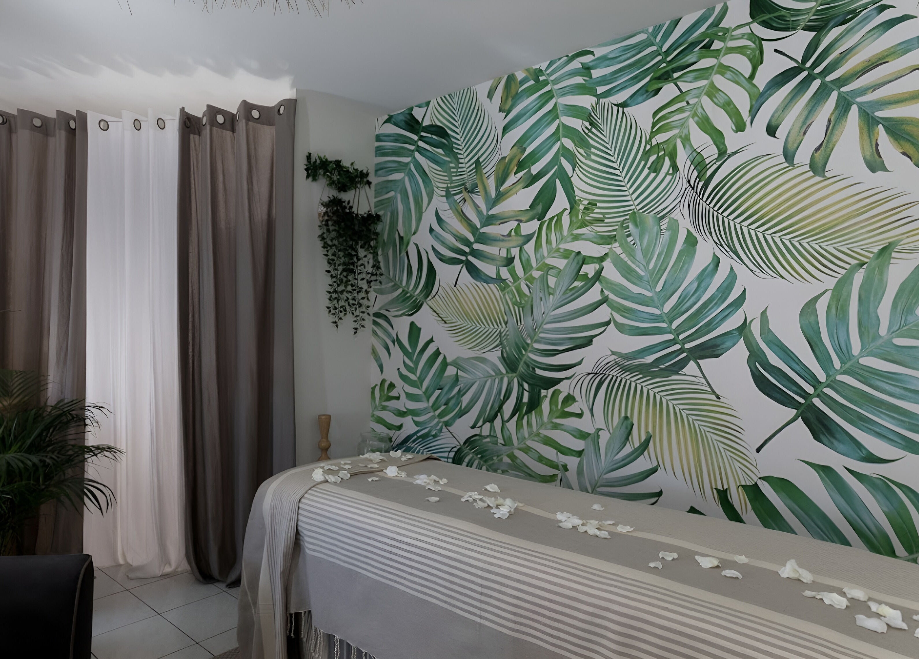 Salle de massage tropicale à Pranaveda, Lyon, Auvergne-Rhône-Alpes, FR avec murs feuillus et ambiance apaisante.