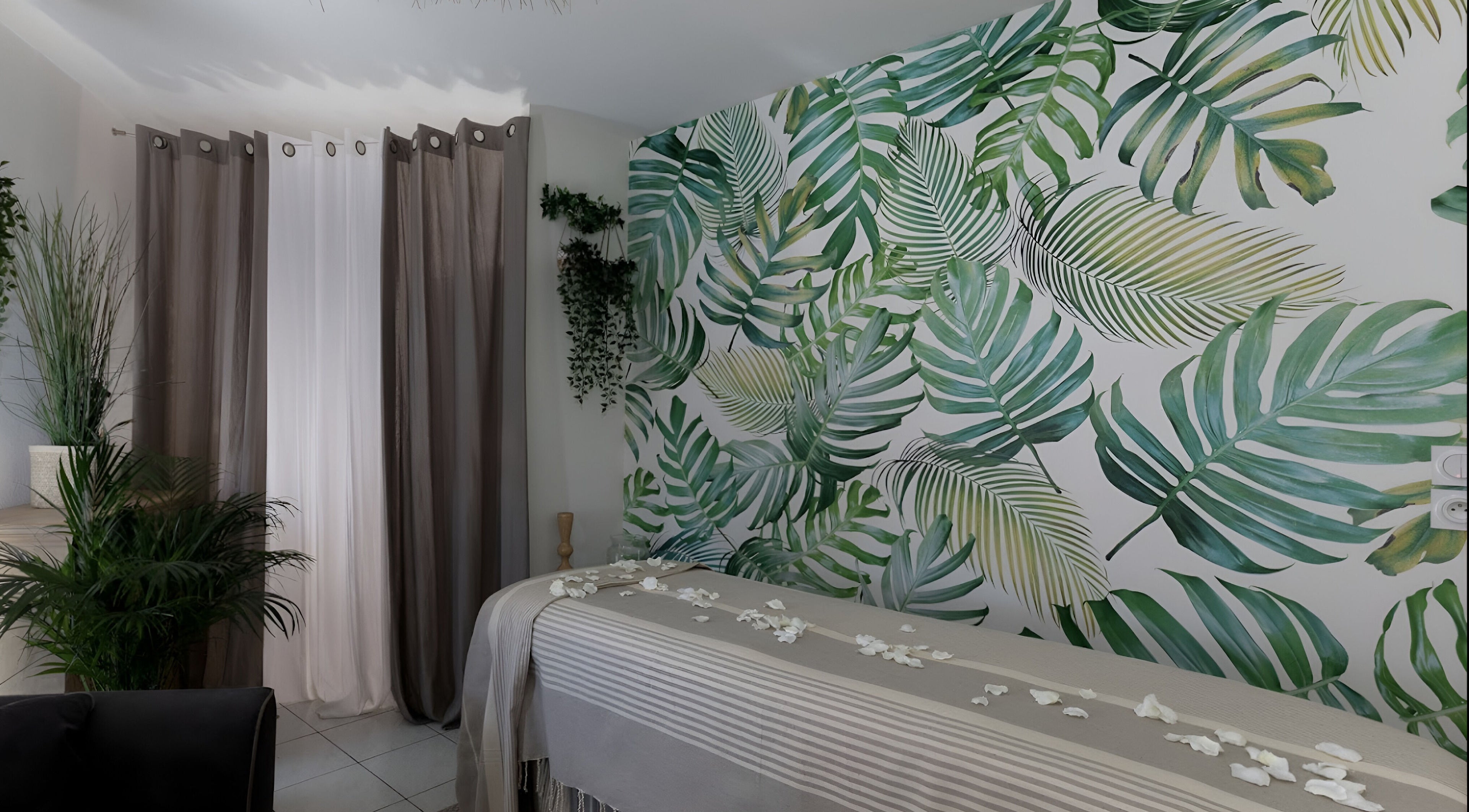 Salle de massage tropicale à Pranaveda, Lyon, Auvergne-Rhône-Alpes, FR avec murs feuillus et ambiance apaisante.