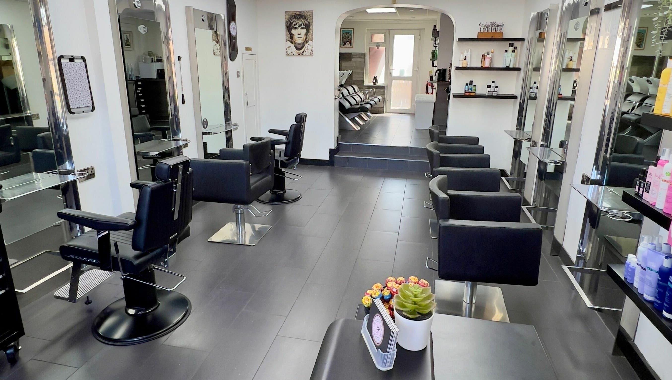 Modern interior of Maverick Hair Studio in Angmering, England, GB with sleek black chairs and styling stations.