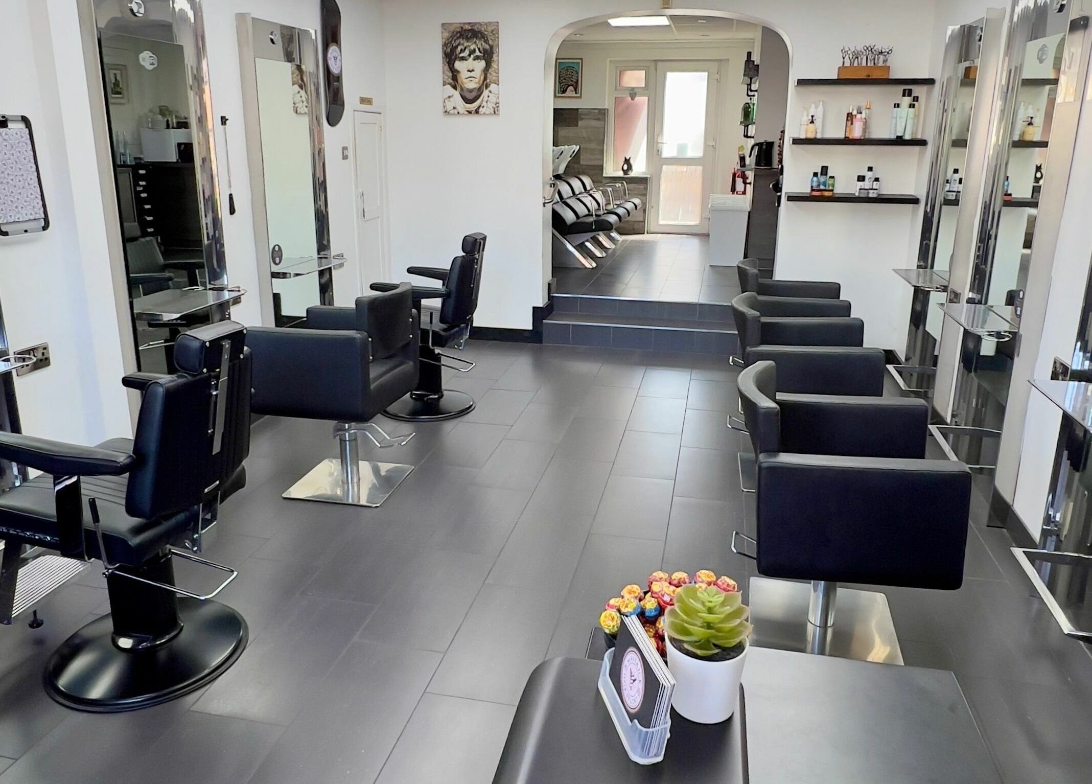 Modern interior of Maverick Hair Studio in Angmering, England, GB with sleek black chairs and styling stations.