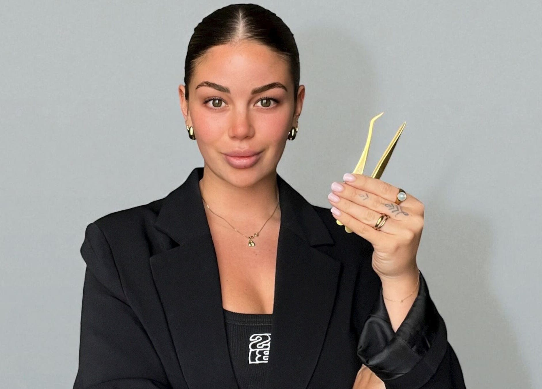 Professional at TAMED by Emily Taylor in St Leonards, NSW, AU holding precision tweezers, showcasing expertise.