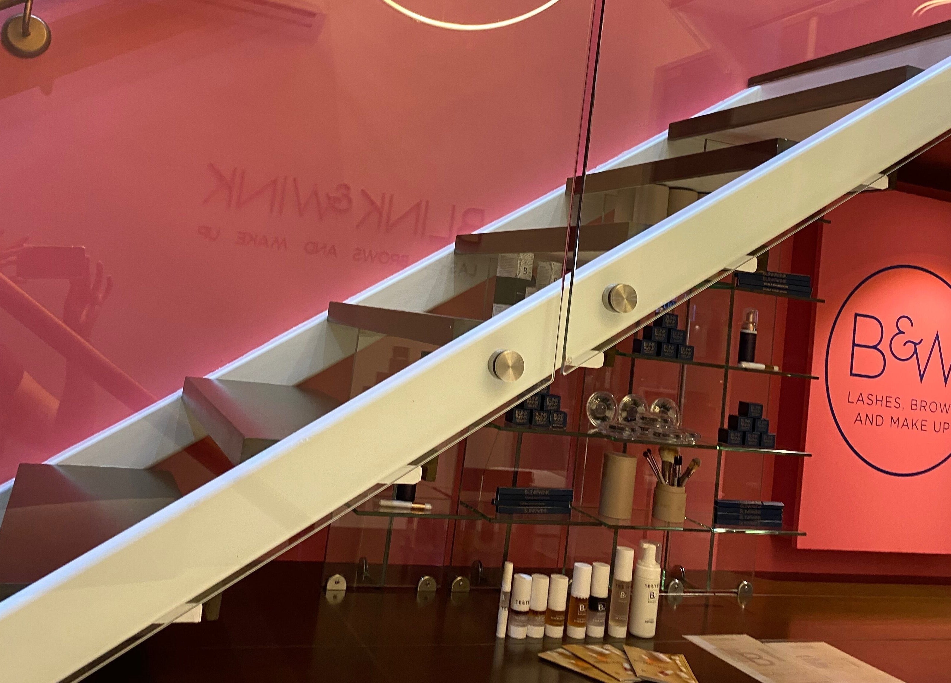Chic staircase at Blink & Wink, Janabiyah, Al-Muḥāfaẓat aš-Šamālīyah BH, showcasing beauty products and branding.