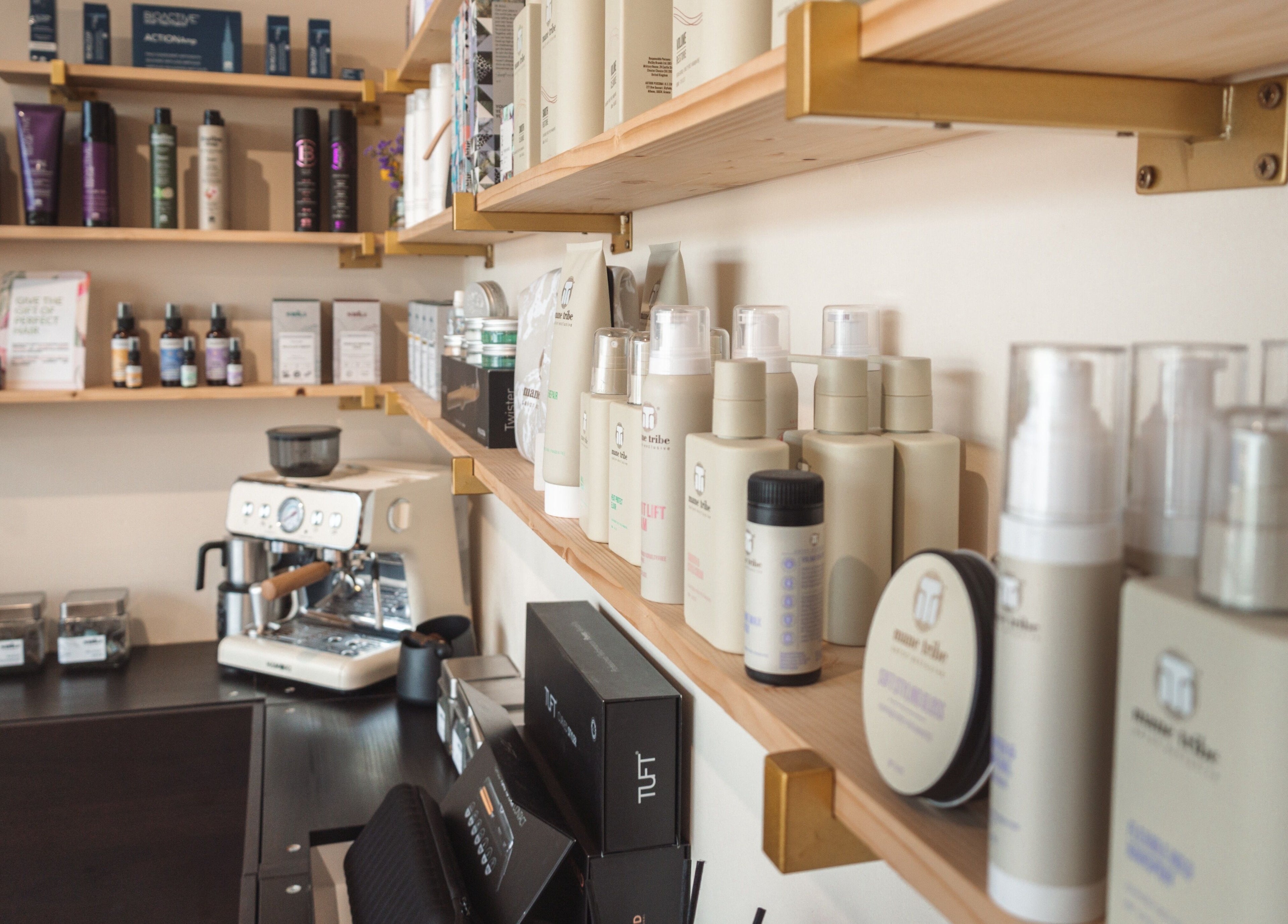Sleek shelves of beauty products at La Bohème Hub, Lisburn, Northern Ireland, GB with a coffee machine.