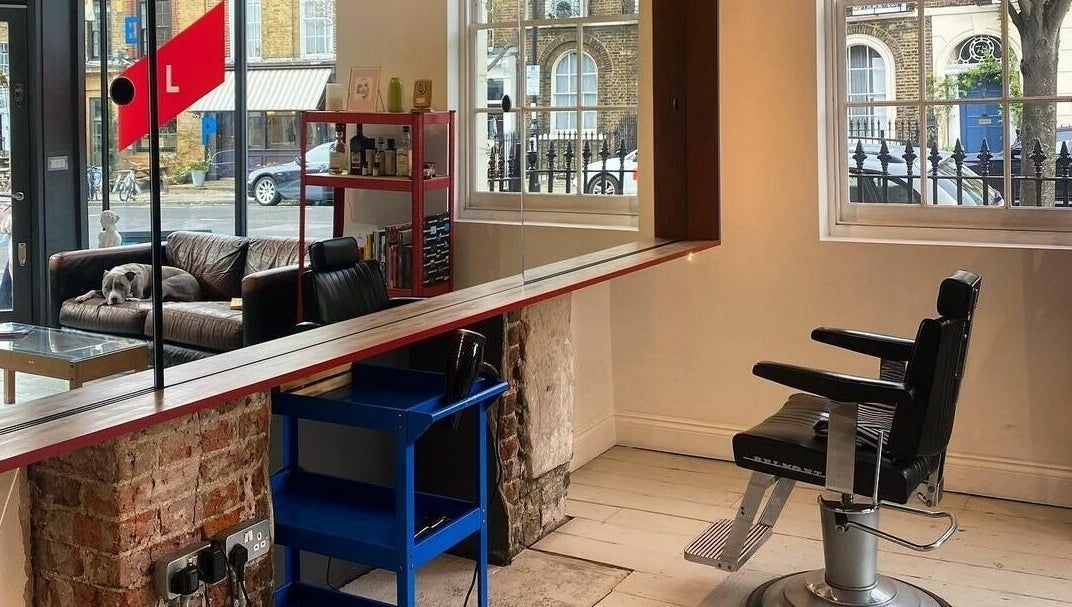 Interior of ELP Barbershop in London, England, GB, featuring a stylish barber chair and cozy seating.