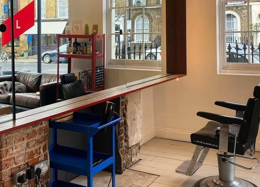 Interior of ELP Barbershop in London, England, GB, featuring a stylish barber chair and cozy seating.
