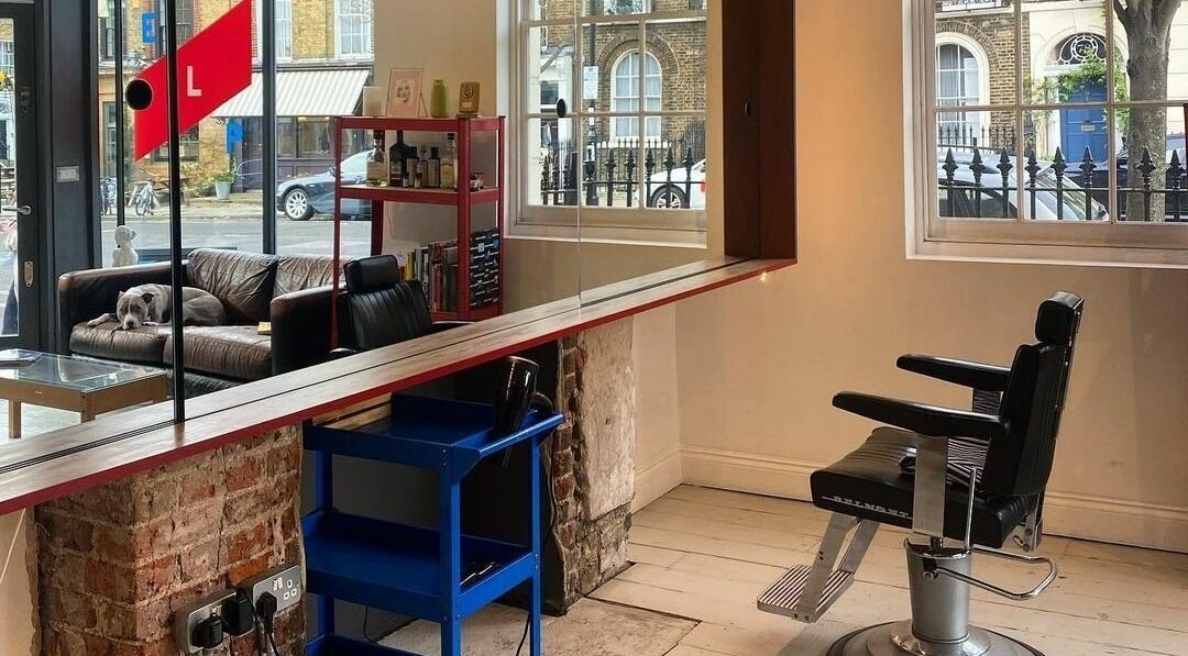 Interior of ELP Barbershop in London, England, GB, featuring a stylish barber chair and cozy seating.