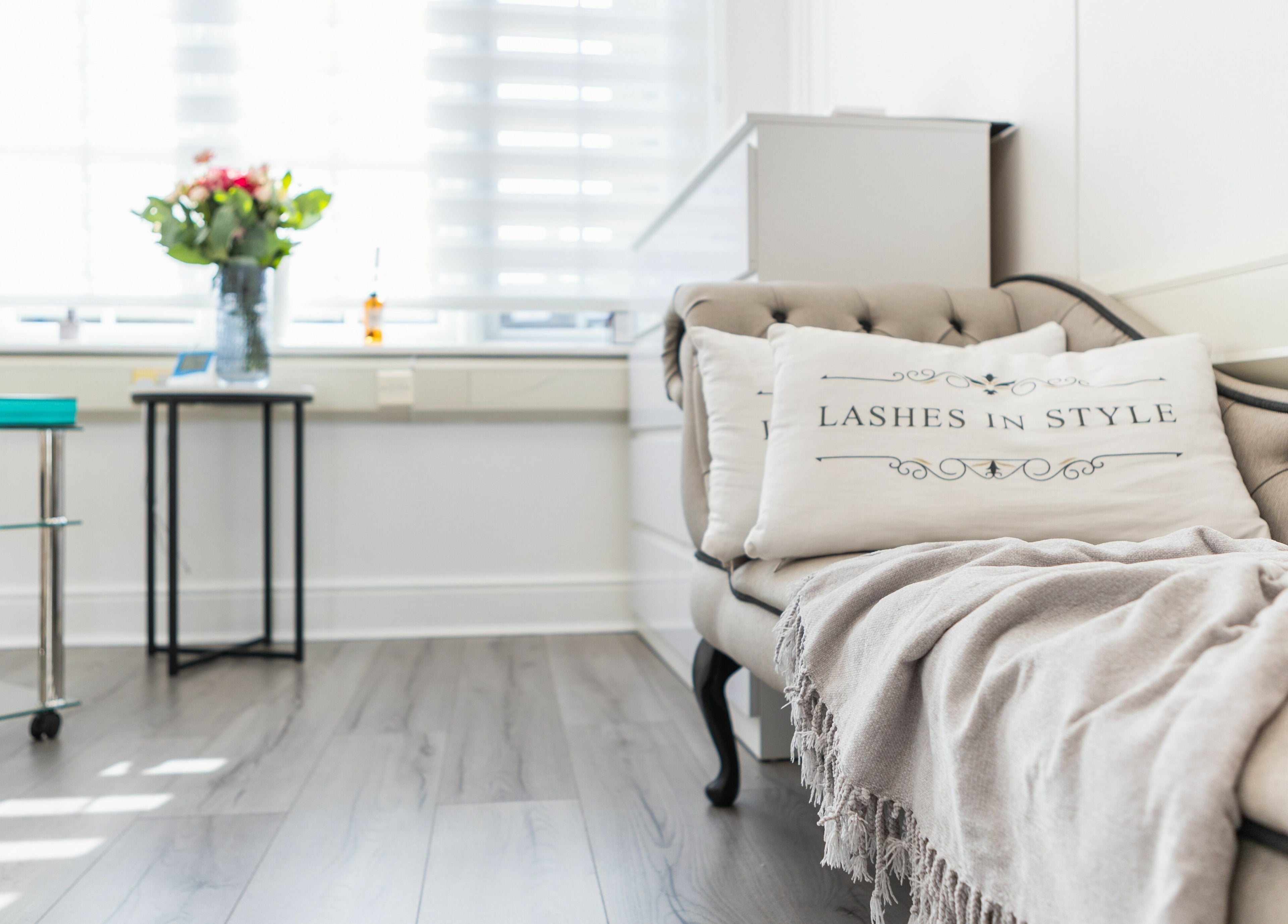 Cozy lounge area at Lashes In Style, London, England, GB with plush seating and decorative pillows.